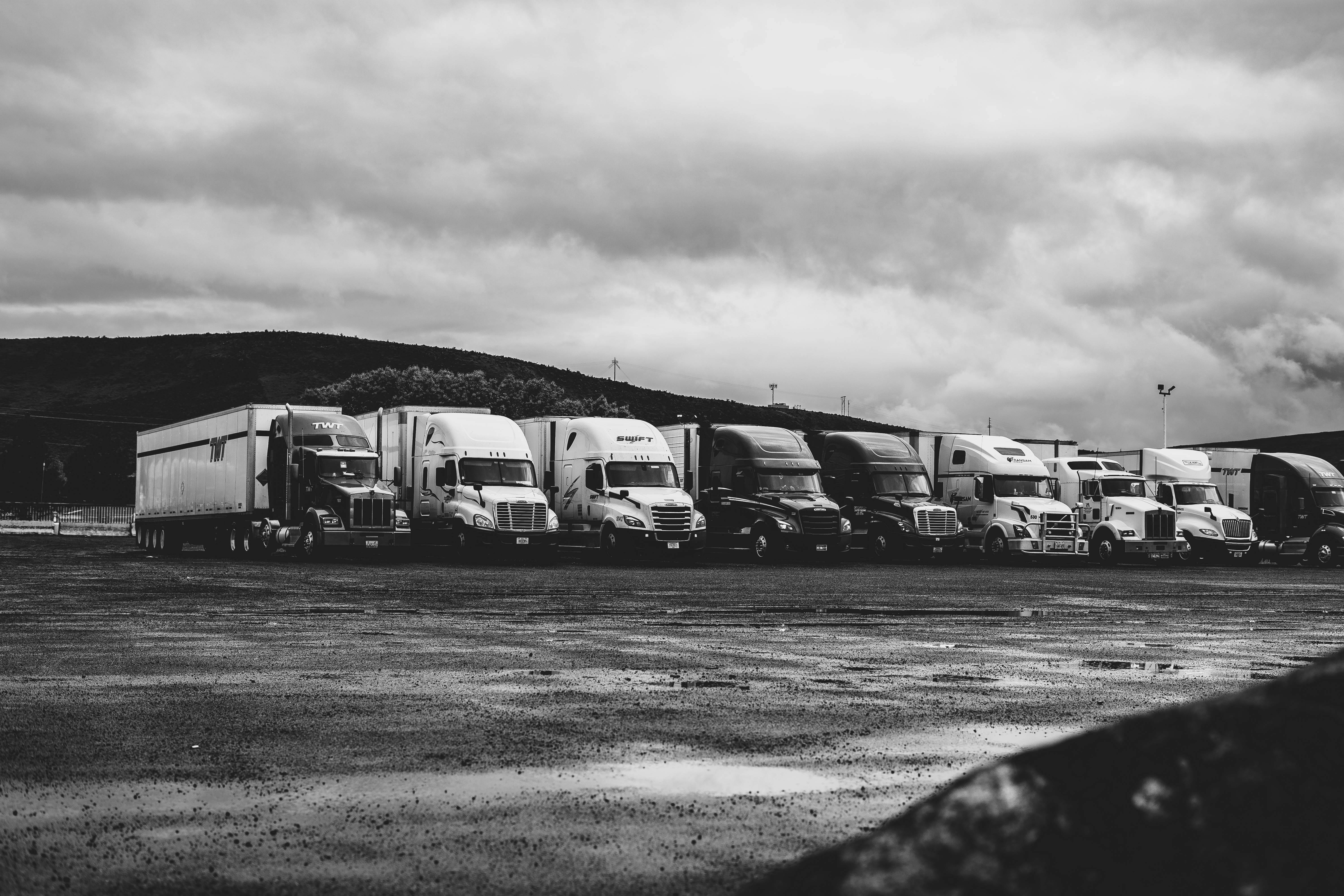 A line of semi trucks are parked next to each other